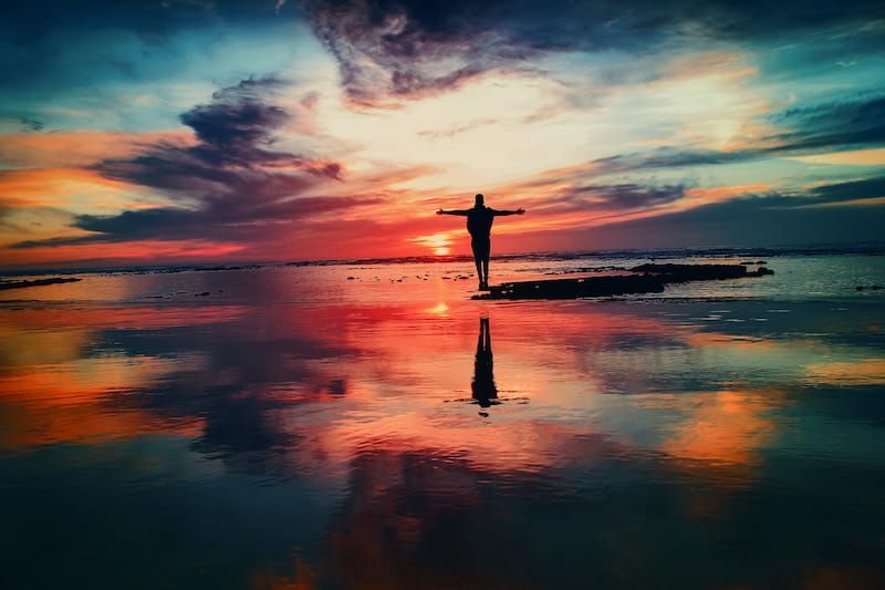 夕日と海をバックにヨガをする人